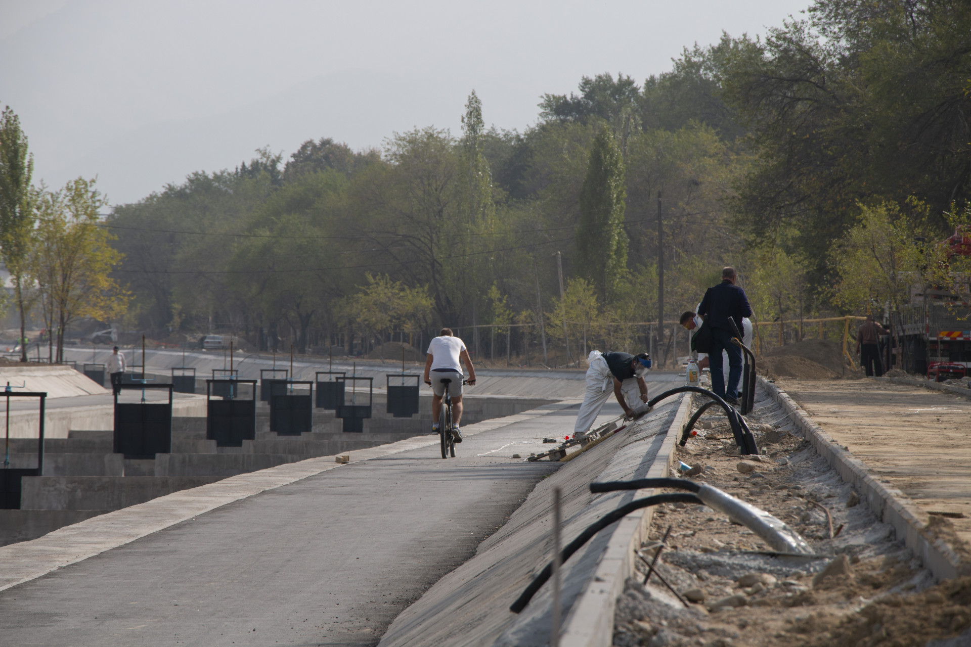 رجل على دراجة هوائية يسير على كورنيش ألما أتا الكبير، حيث يتم إجراء أعمال إعادة الإعمار، سبتمبر 2025.